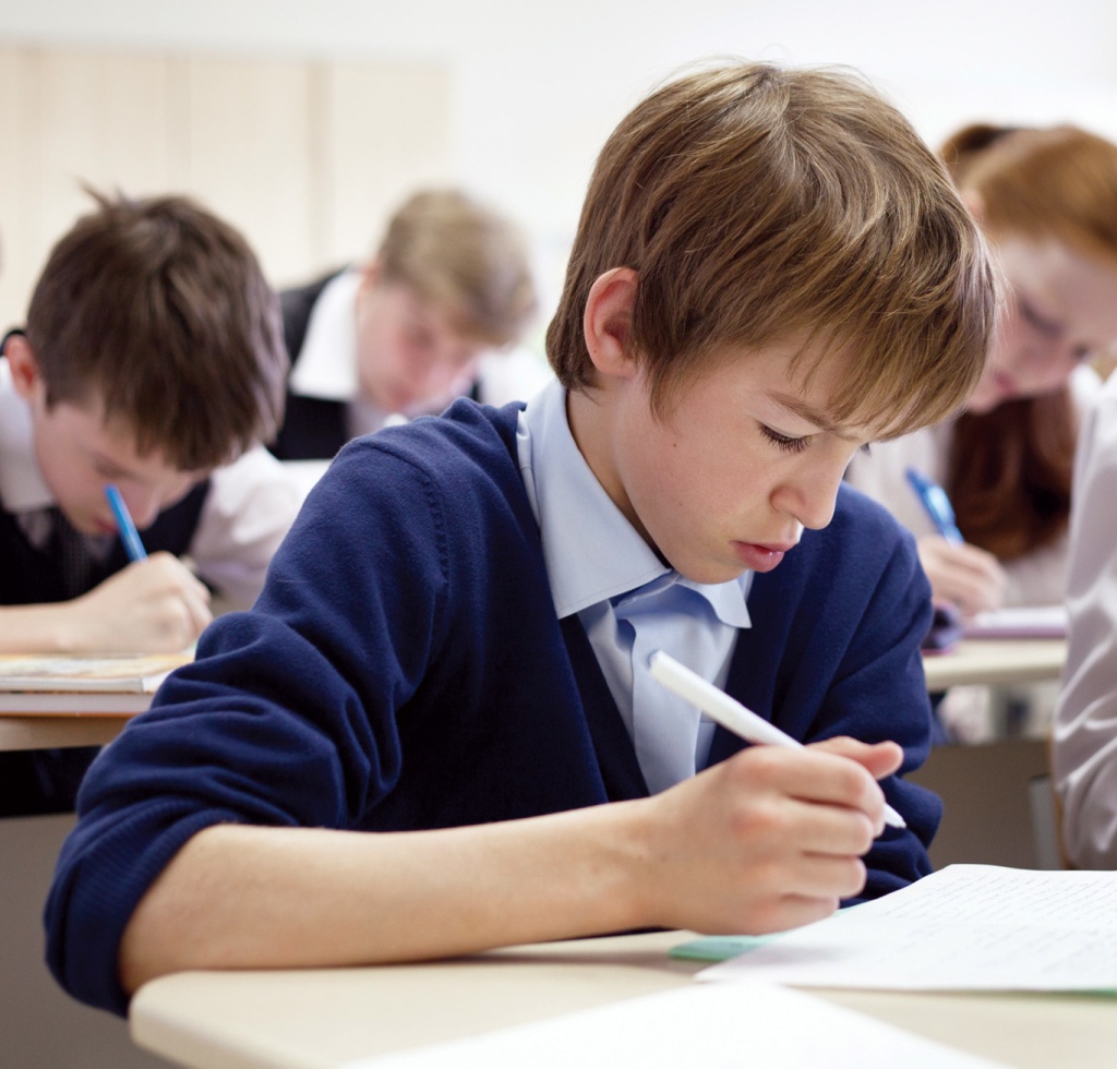 school boy struggling to finish test in class.